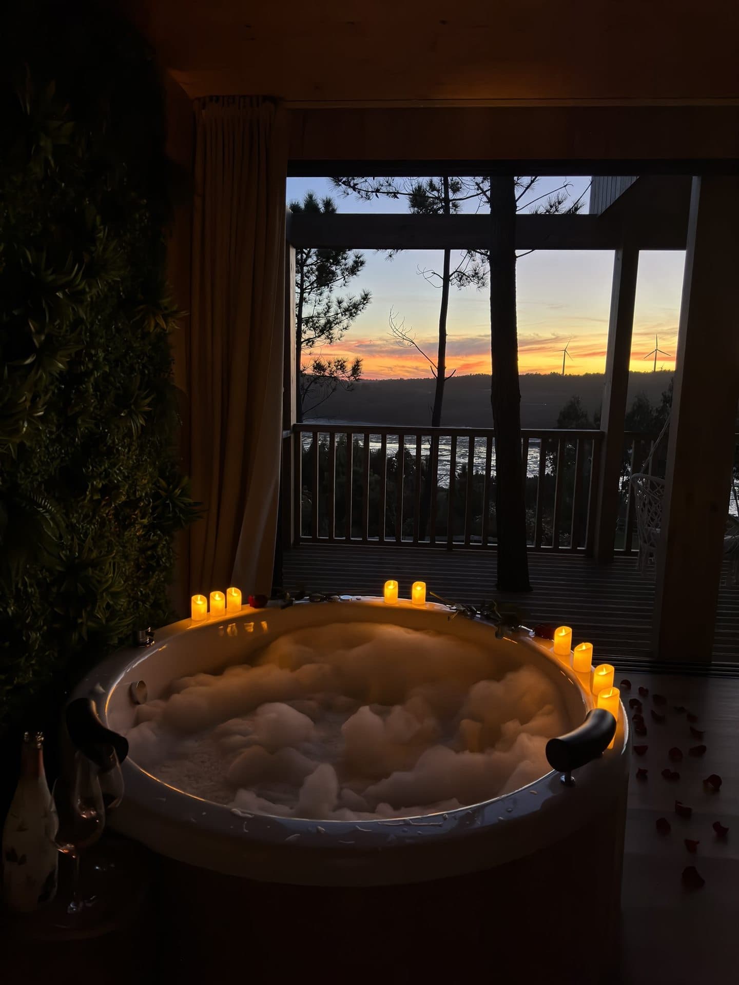 Jacuzzi con velas frente al atardecer en Cabañas da Luz